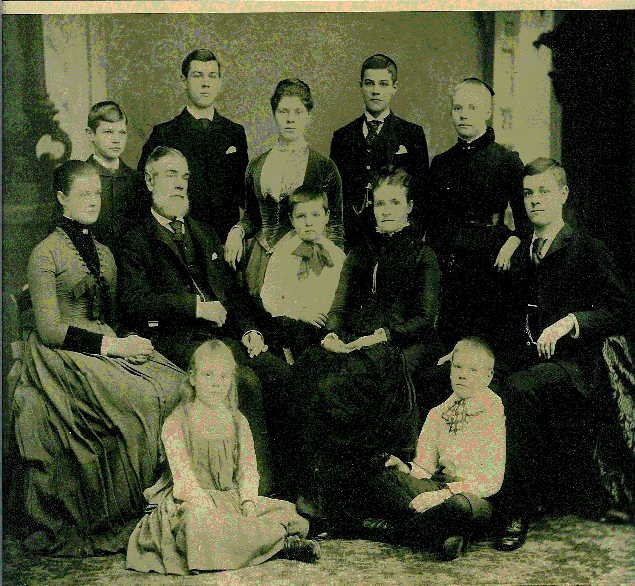 Studio portrait, circa 1888: Hampden Evans Tener I, bearded, and Eliza Frost Tener seated at centre, surrounded by their ten surviving children, from grown sons in dark suits to the two youngest seated on the floor